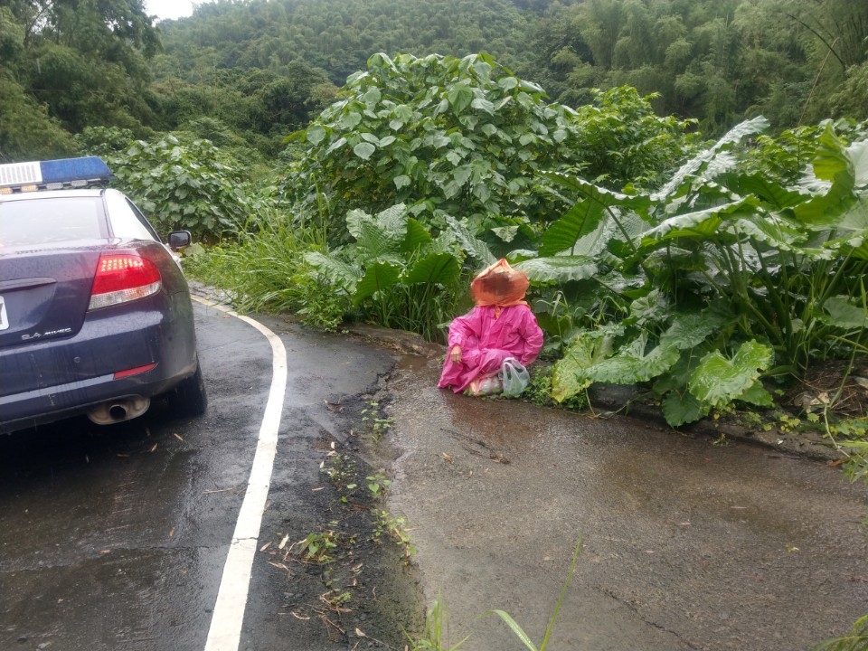 雨天老婦體力不支蹲坐路中　美濃警溫馨護送。(記者劉明吉翻攝)